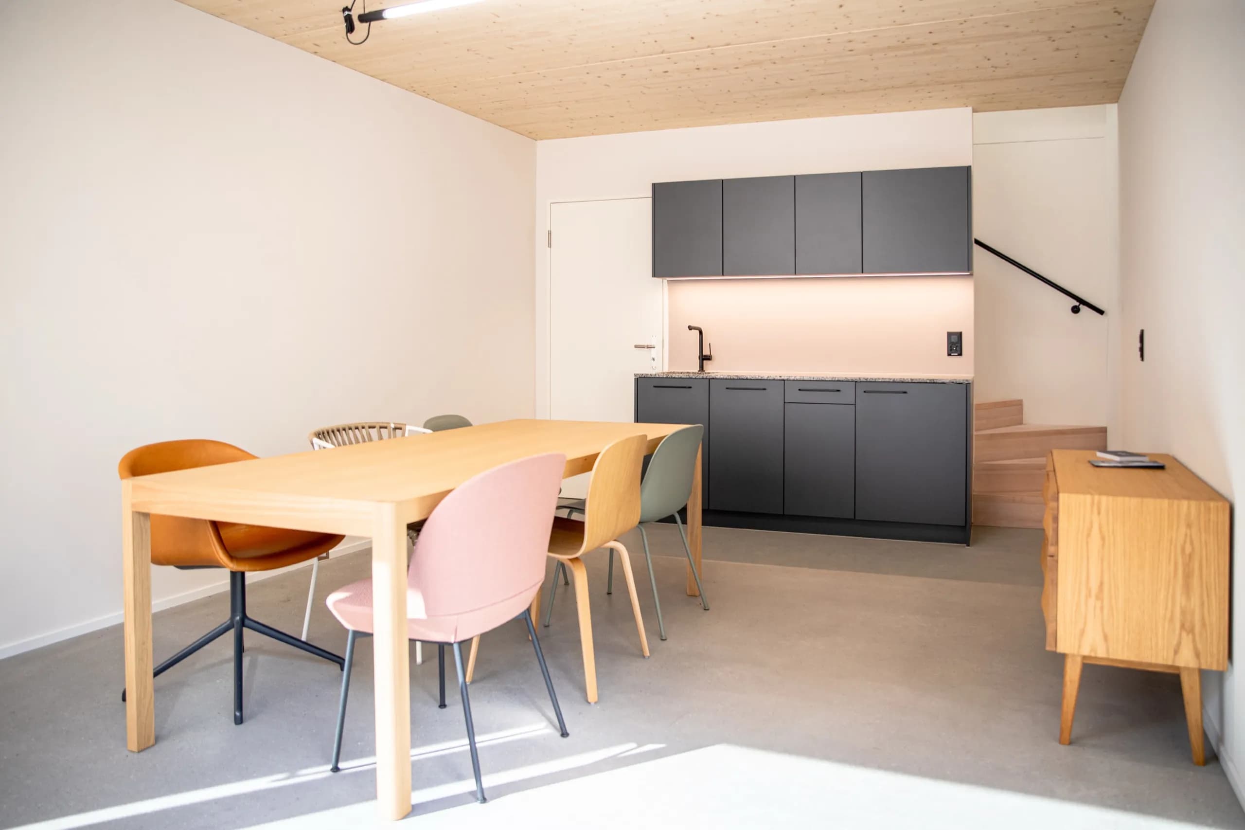 Wohnraum mit von Mion AG verlegtem fugenlosem Boden, Sichtbeton-Decke, Eichenholzküche, helle Atmosphäre