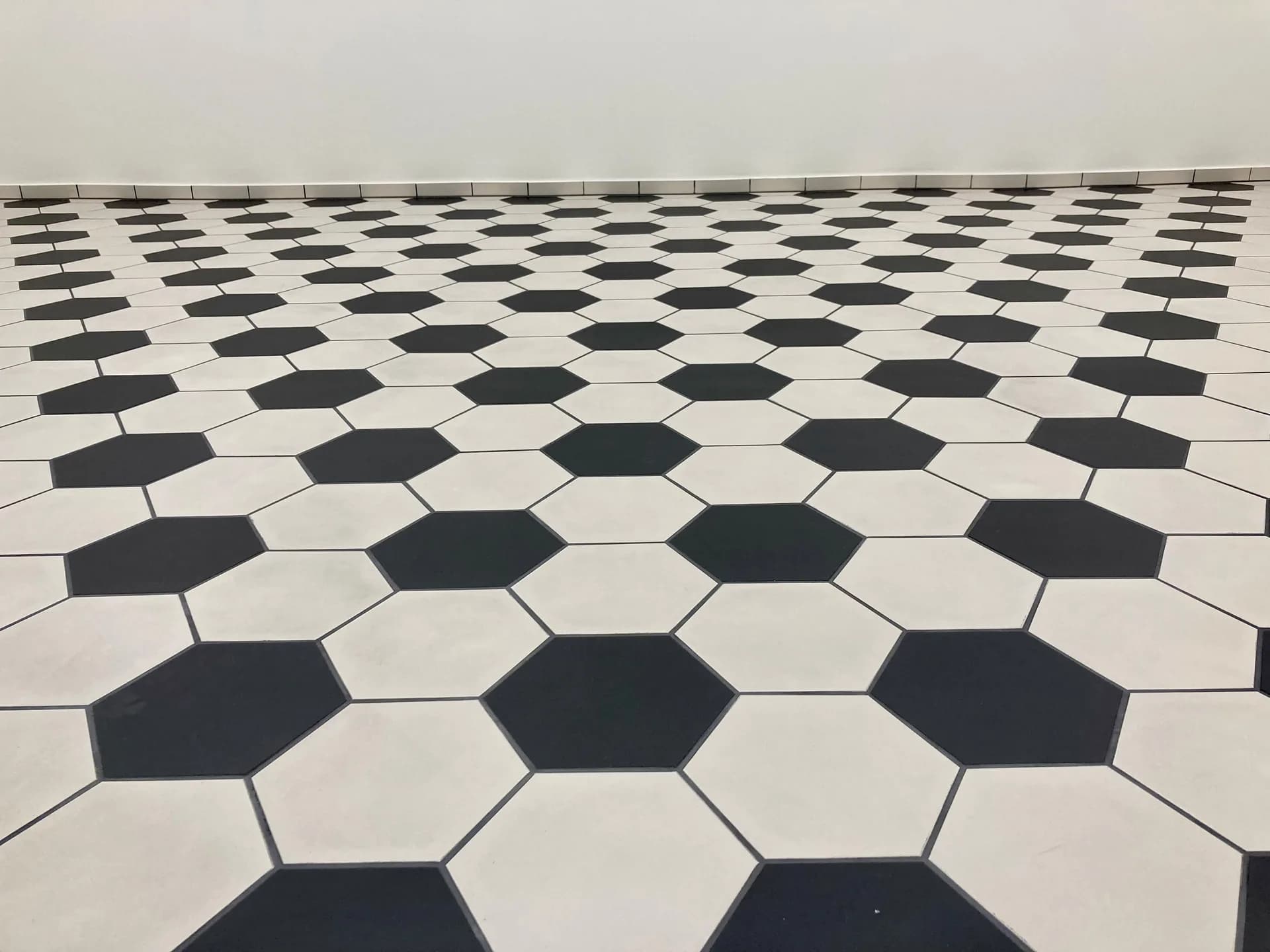 Hexagonale Keramik-Bodenplatten in Schwarz-Weiss, verlegt von Mion Plattenbeläge GmbH
