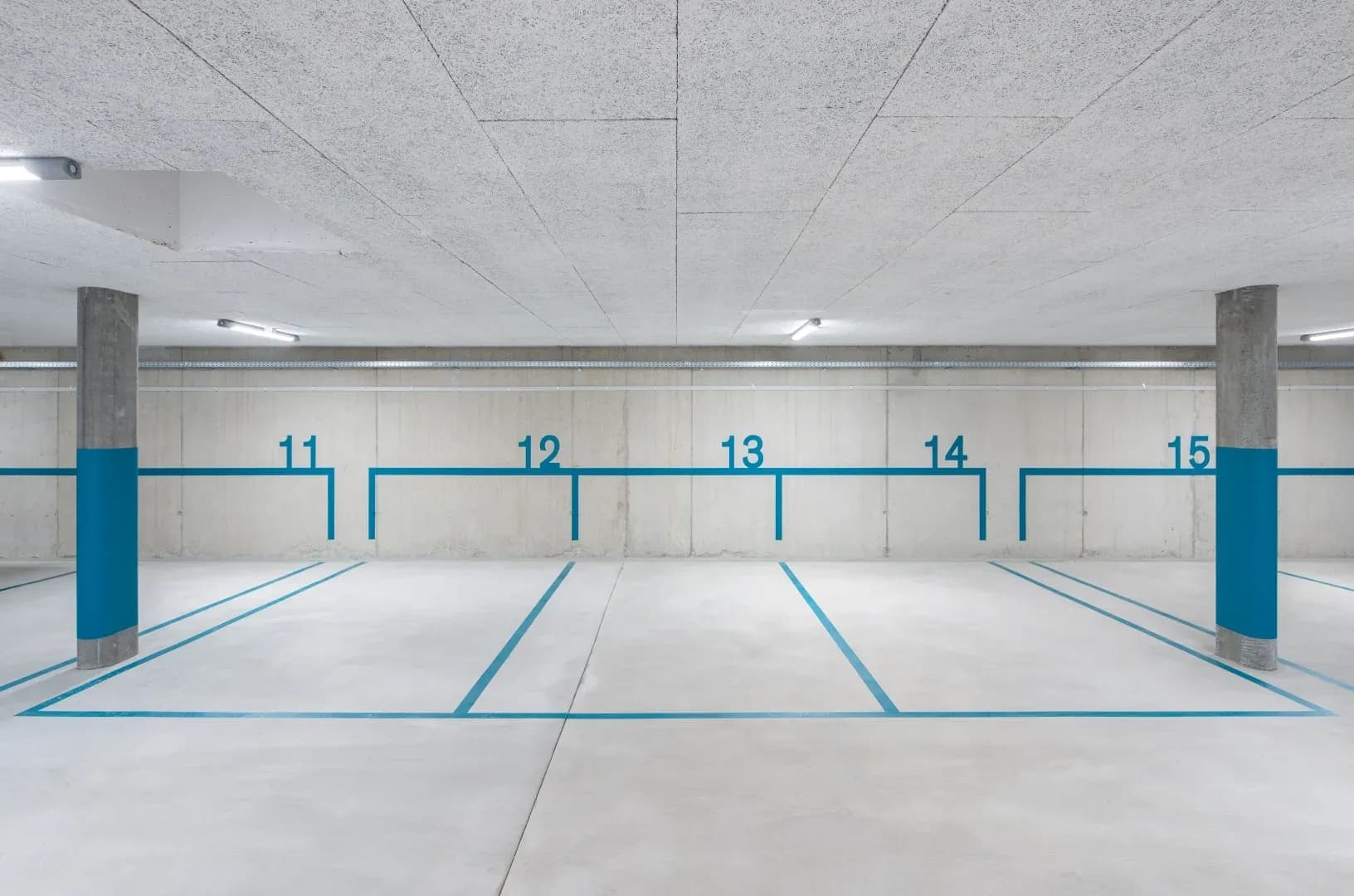 Parkgarage mit Hartbetonbelag und blauen Parkplatz-Markierungen